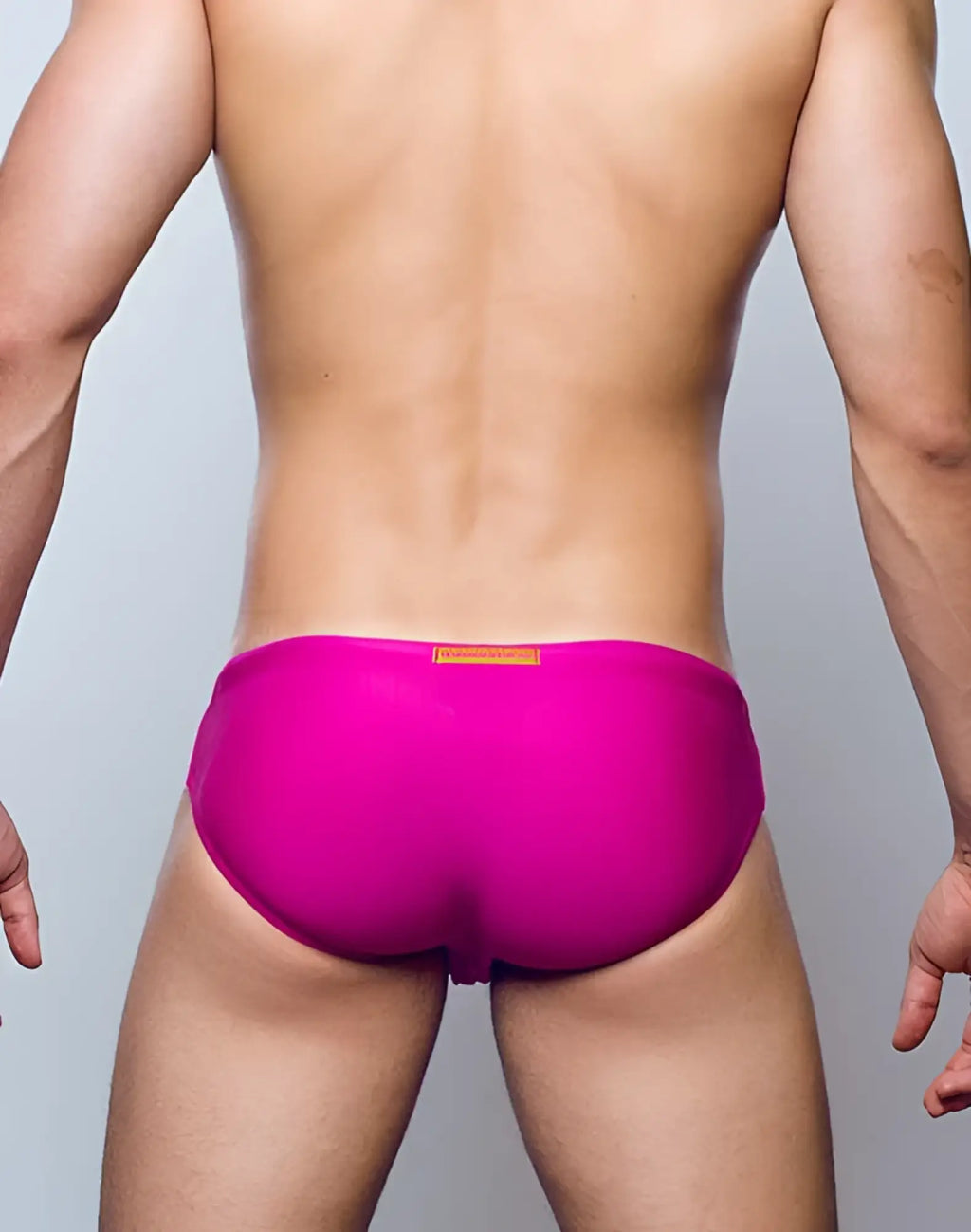 Bright fuchsia 2EROS V10 Core Series 2 swim trunks with subtle orange rectangular tag at the waistband