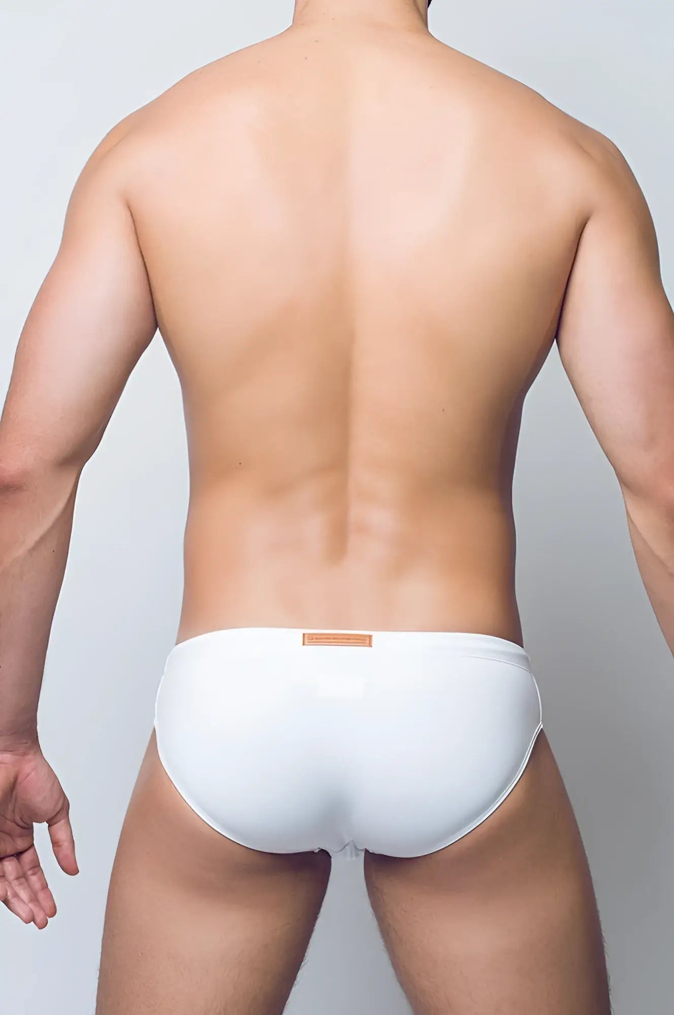 White 2eros v10 core swim brief with a tan rectangular tag on the waistband designed for swimwear use
