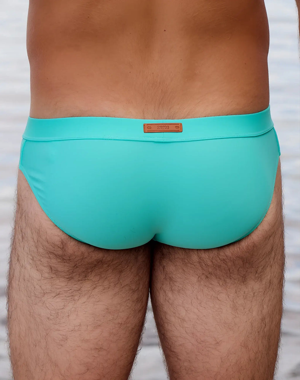 Turquoise 2eros v10 encore swim brief with brown leather-like brand tag at waistband in neon blue color