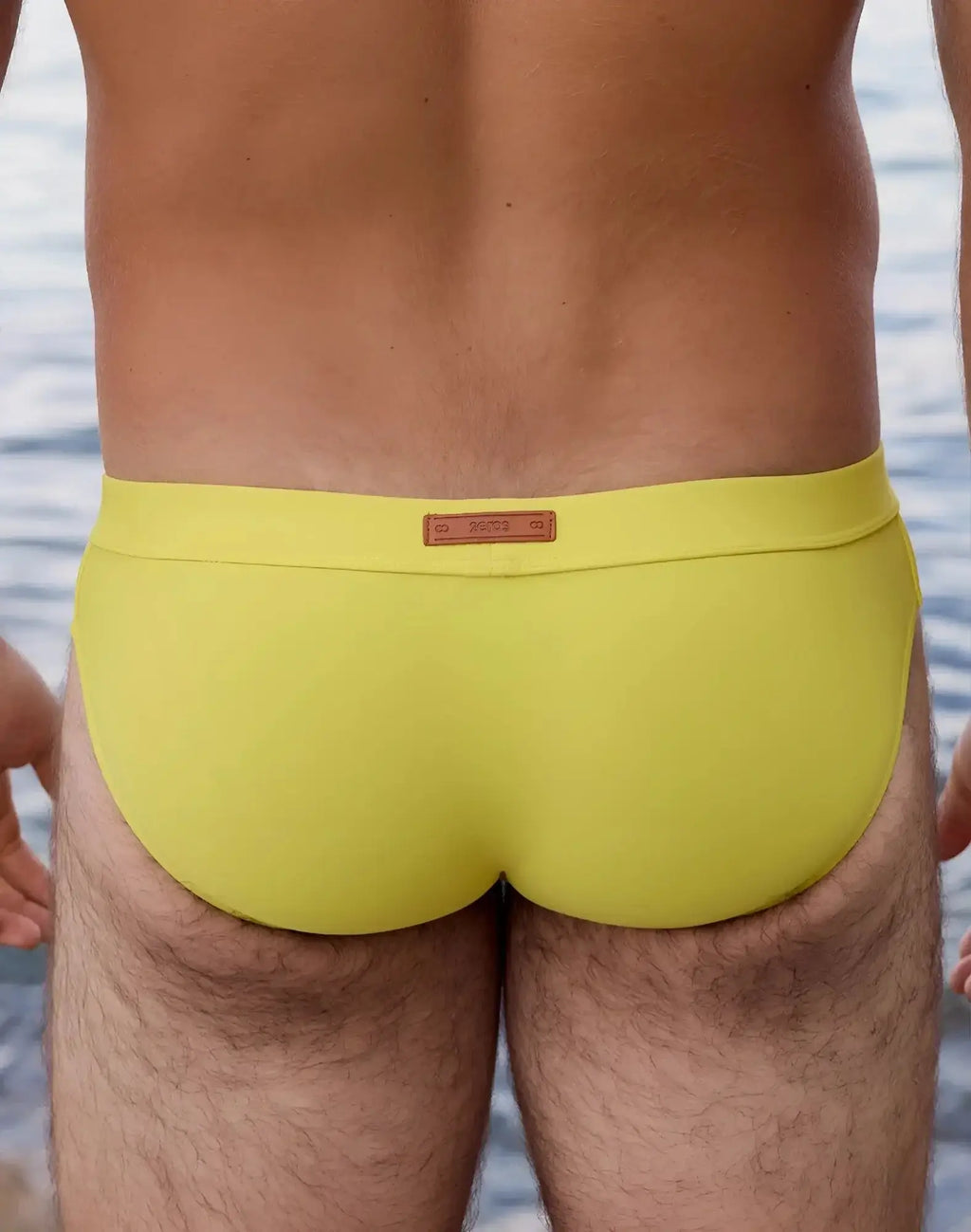 Bright yellow 2EROS V10 Encore swim brief with brown leather-like waistband label designed for swimming use