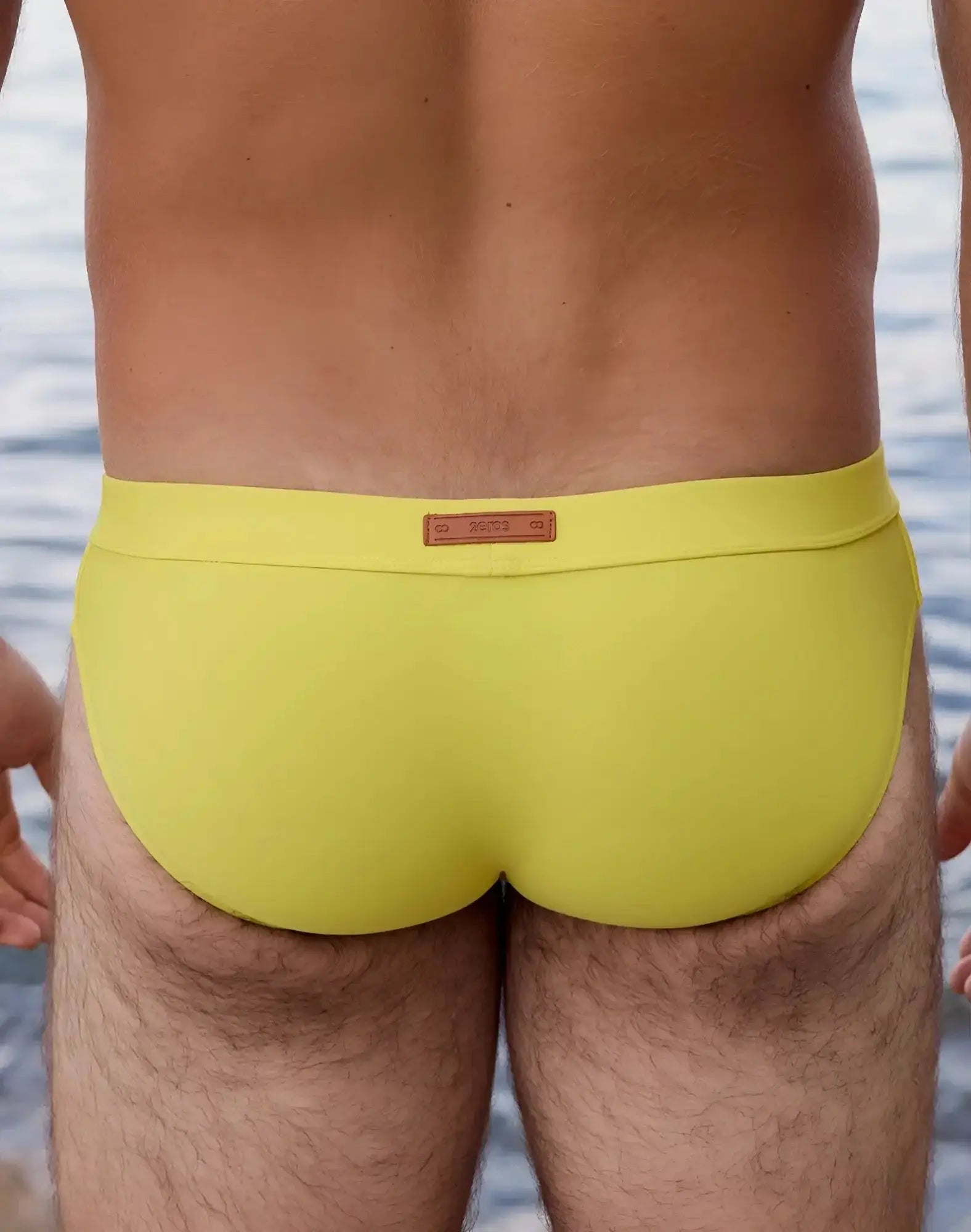 Bright yellow 2EROS V10 Encore swim brief with brown leather-like waistband label designed for swimming use