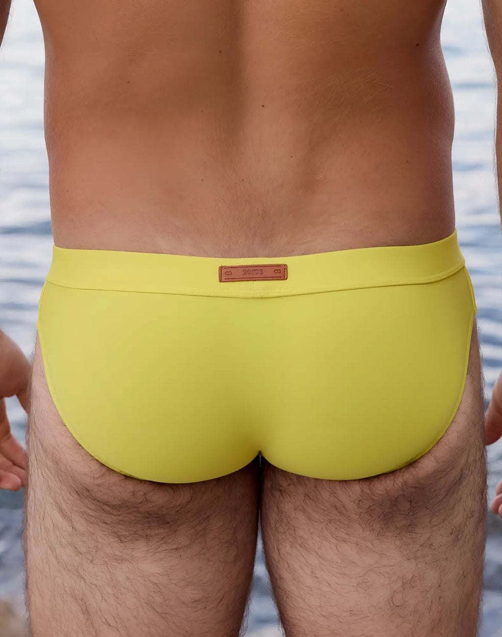 Bright yellow 2EROS V10 Encore swim brief with brown leather-like waistband label designed for swimming use