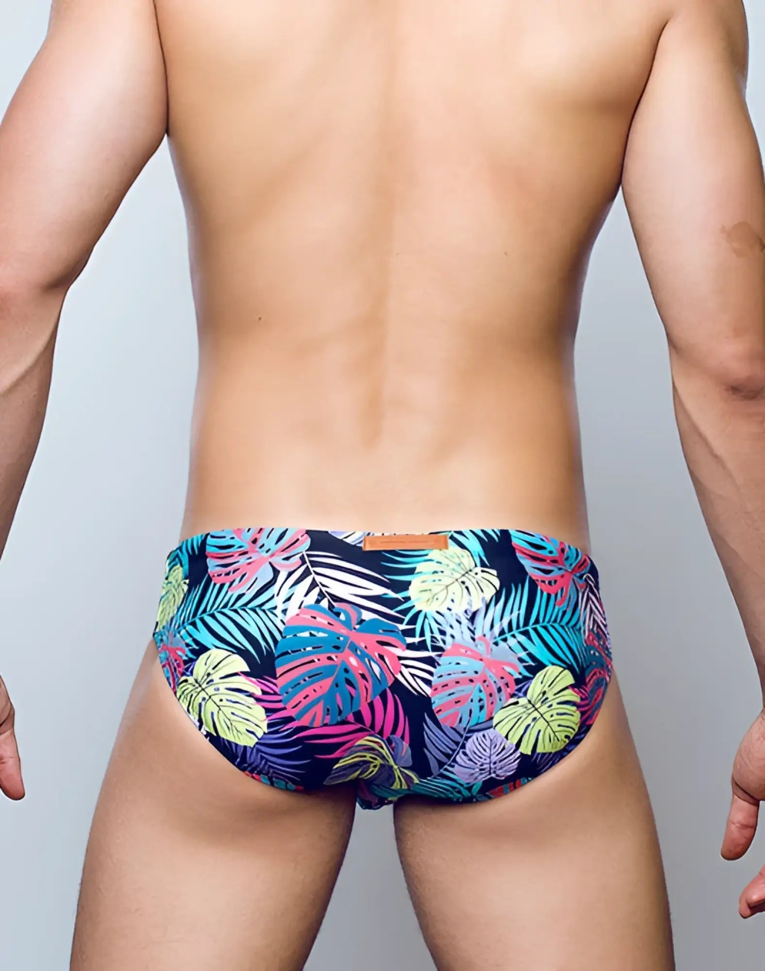 2EROS V10 Print swimwear featuring vibrant tropical leaf-patterned trunks in navy blue pink teal and lime green
