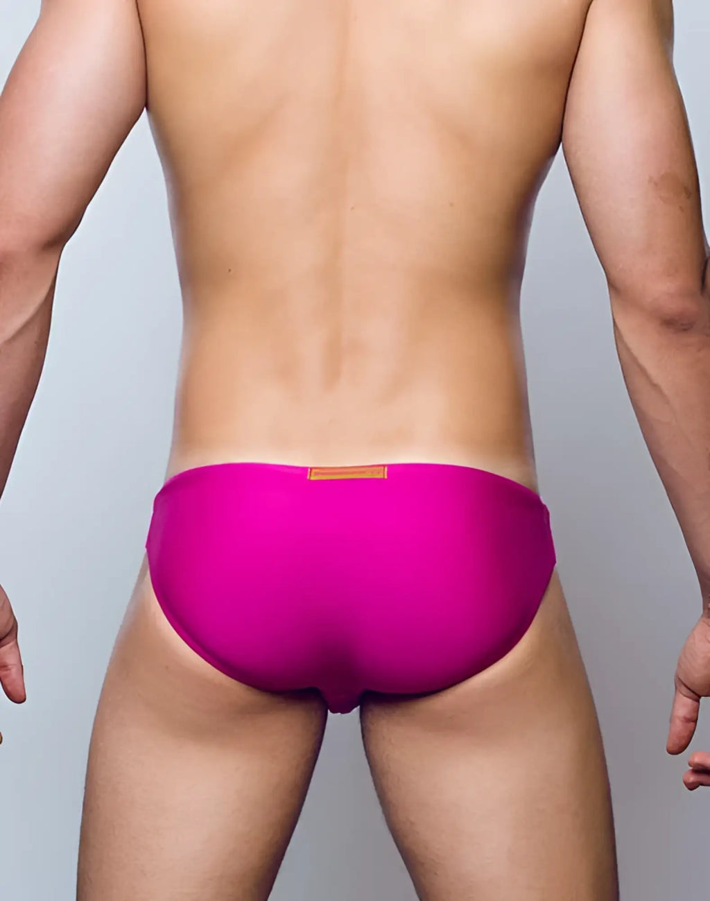 Vibrant fuchsia red 2eros v20 core swim trunks with a small tan rectangular tag at the waistband