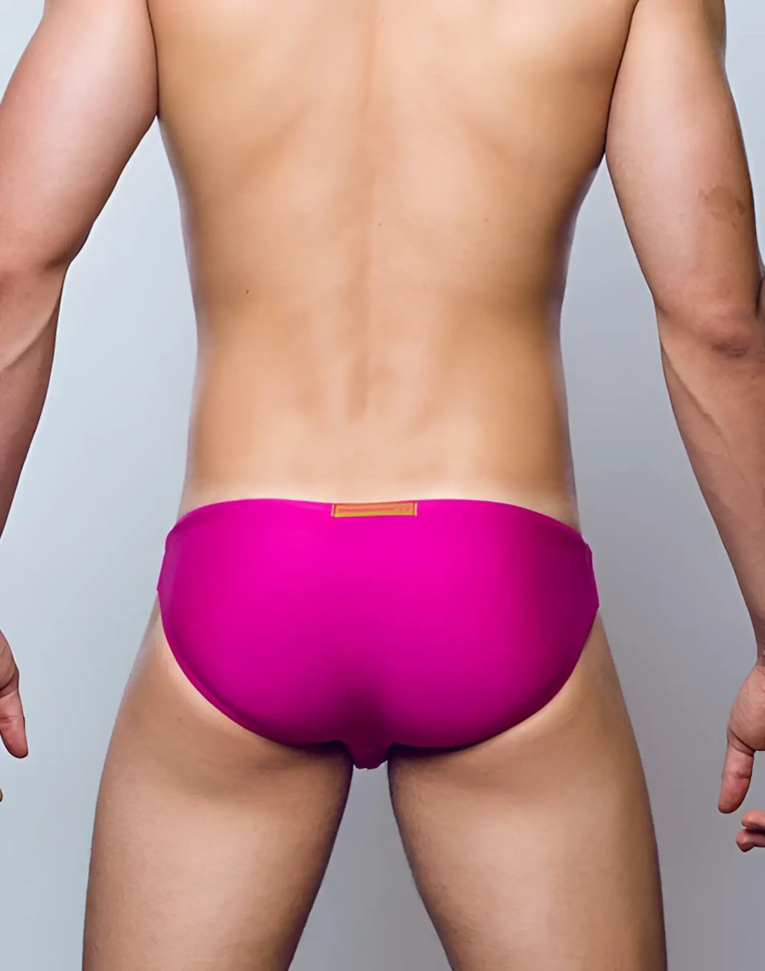 Vibrant fuchsia red 2eros v20 core swim trunks with a small tan rectangular tag at the waistband