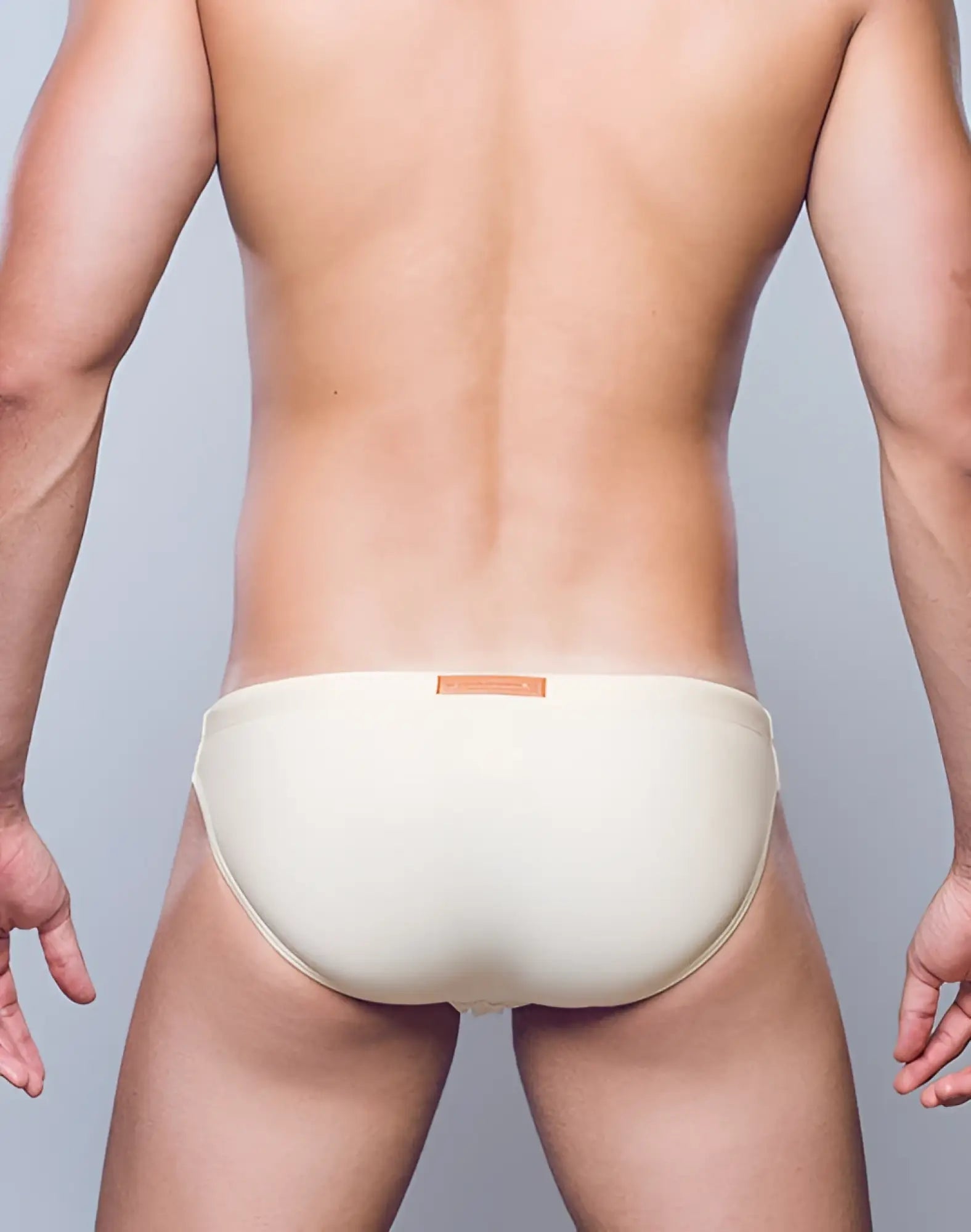 Cream-colored seamless 2EROS V20 Core swimwear briefs with subtle orange waistband label in sand color