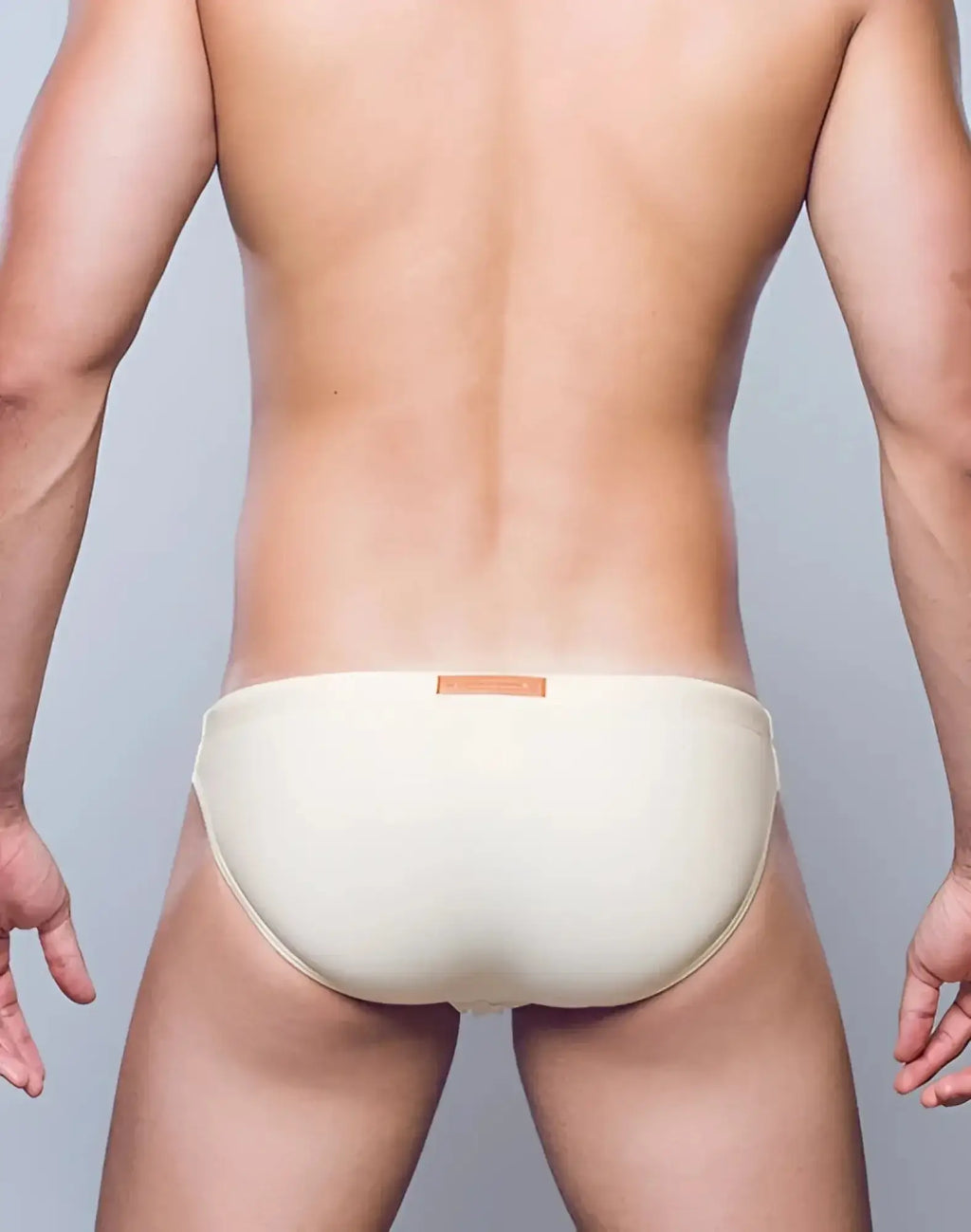 Cream-colored seamless 2EROS V20 Core swimwear briefs with subtle orange waistband label in sand color