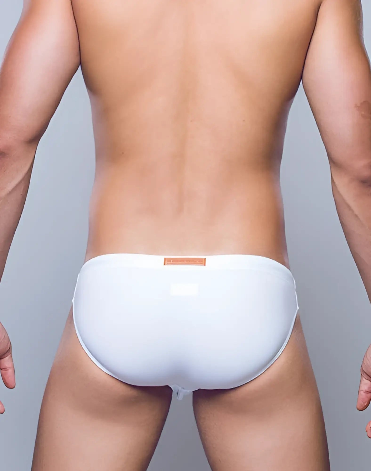 White glossy 2EROS V20 Core swimwear trunks with a small orange label at the waistband for swimming use