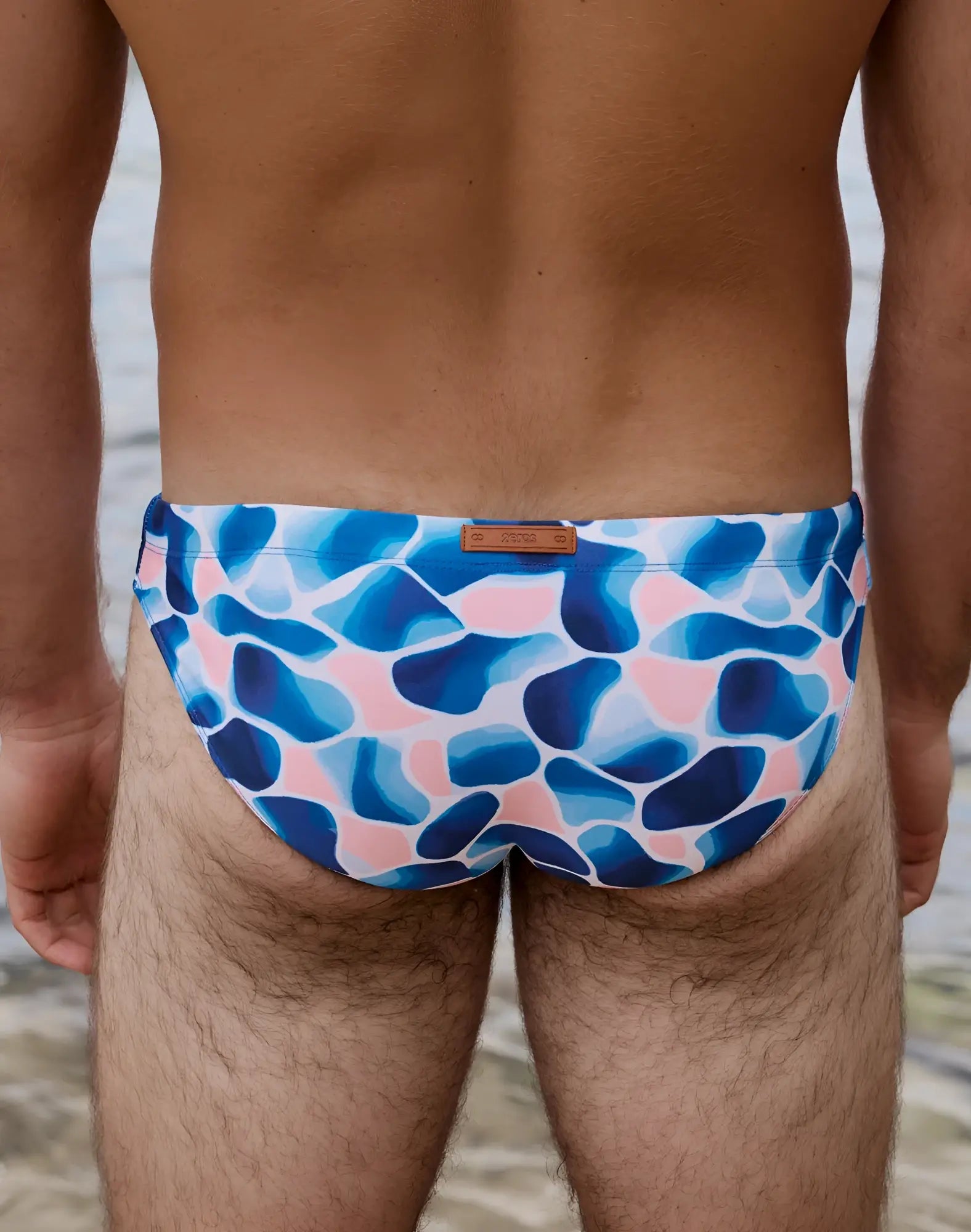 Blue and pink abstract patterned 2EROS V20 printed swim brief with brown leather-like brand tag in aqua navy colors