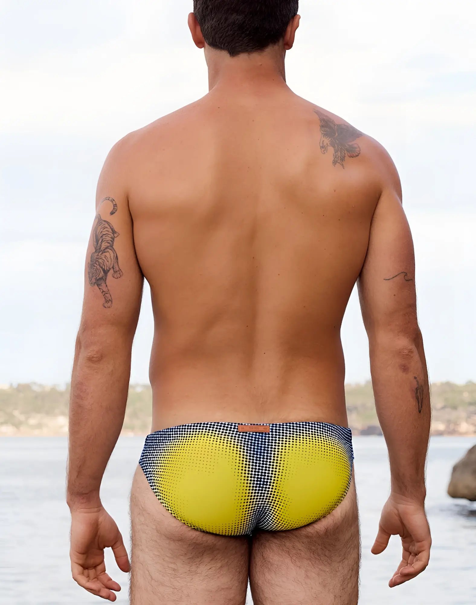 2eros v20 printed swim brief in bright yellow and navy blue checkered pattern with gradient dot design