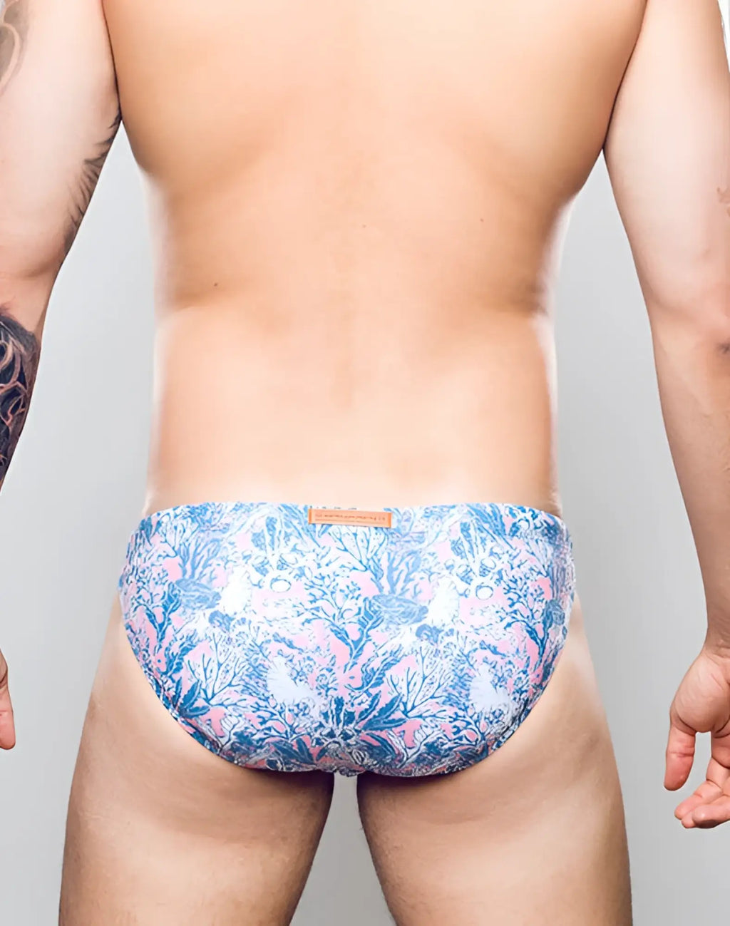 2eros v20 printed swim brief in coral teal with blue and pink floral pattern and subtle sheen on men’s swimwear