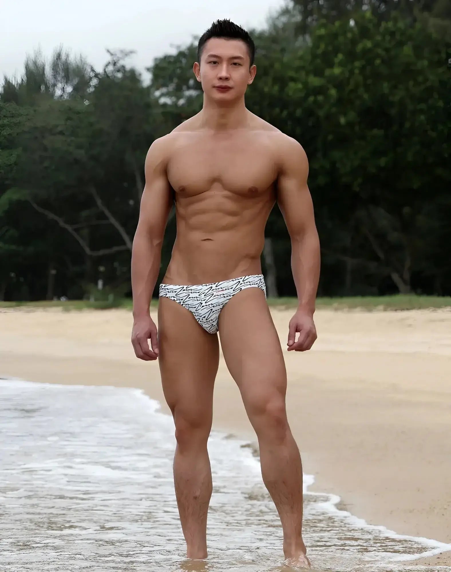 White swim briefs by 2EROS with black repeating logo pattern designed for beach and pool use