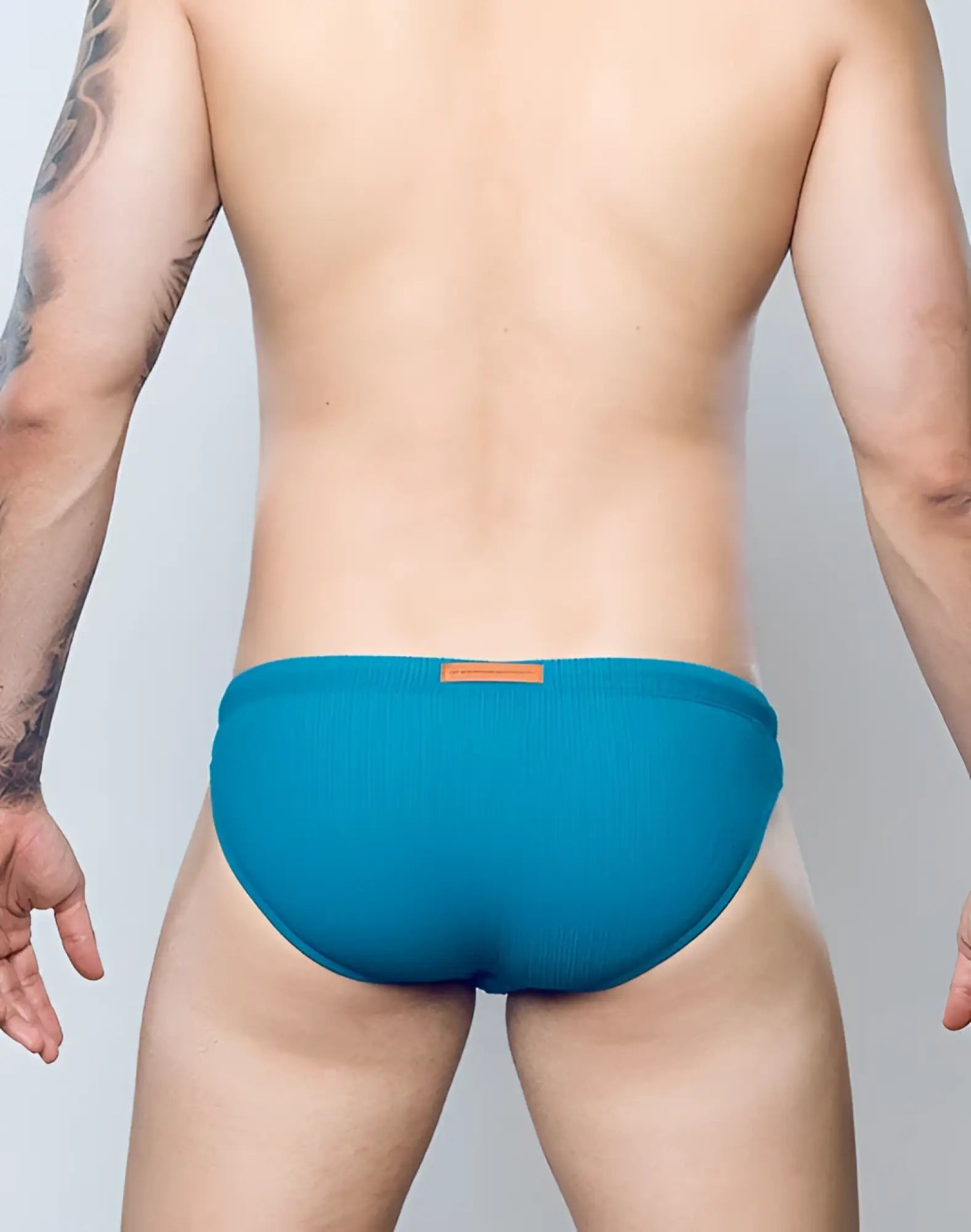 Teal ribbed swim briefs by 2EROS with a small brown leather patch at the waistband in railroad teal color