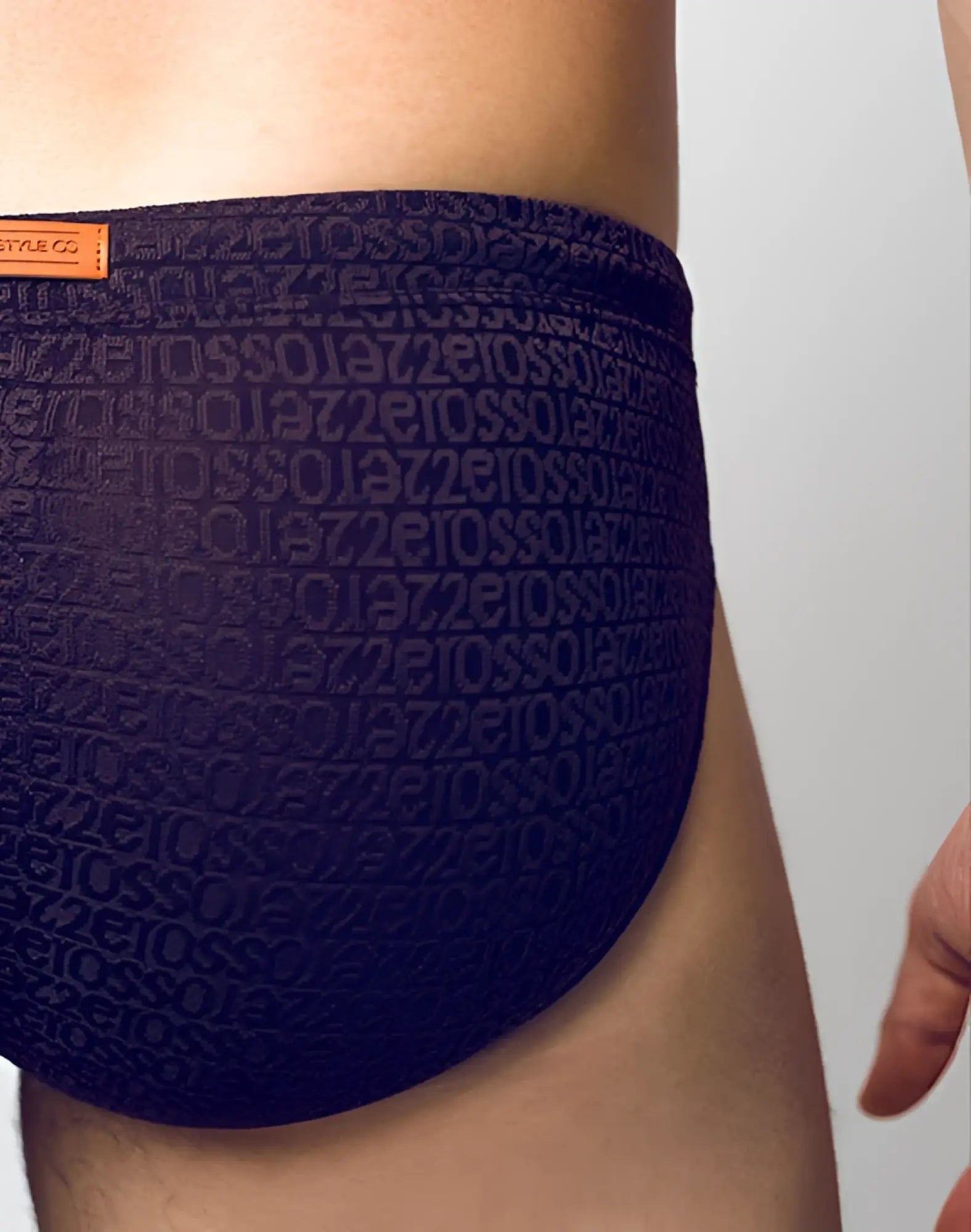 Dark blue 2eros v30 textured swim brief with embossed repeating text pattern on the fabric signet black color