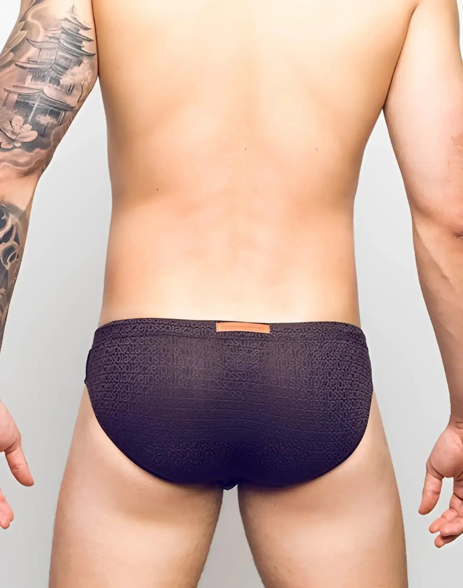 Dark purple 2eros v30 textured swim briefs with subtle pattern and orange leather-like waistband tag in signet black