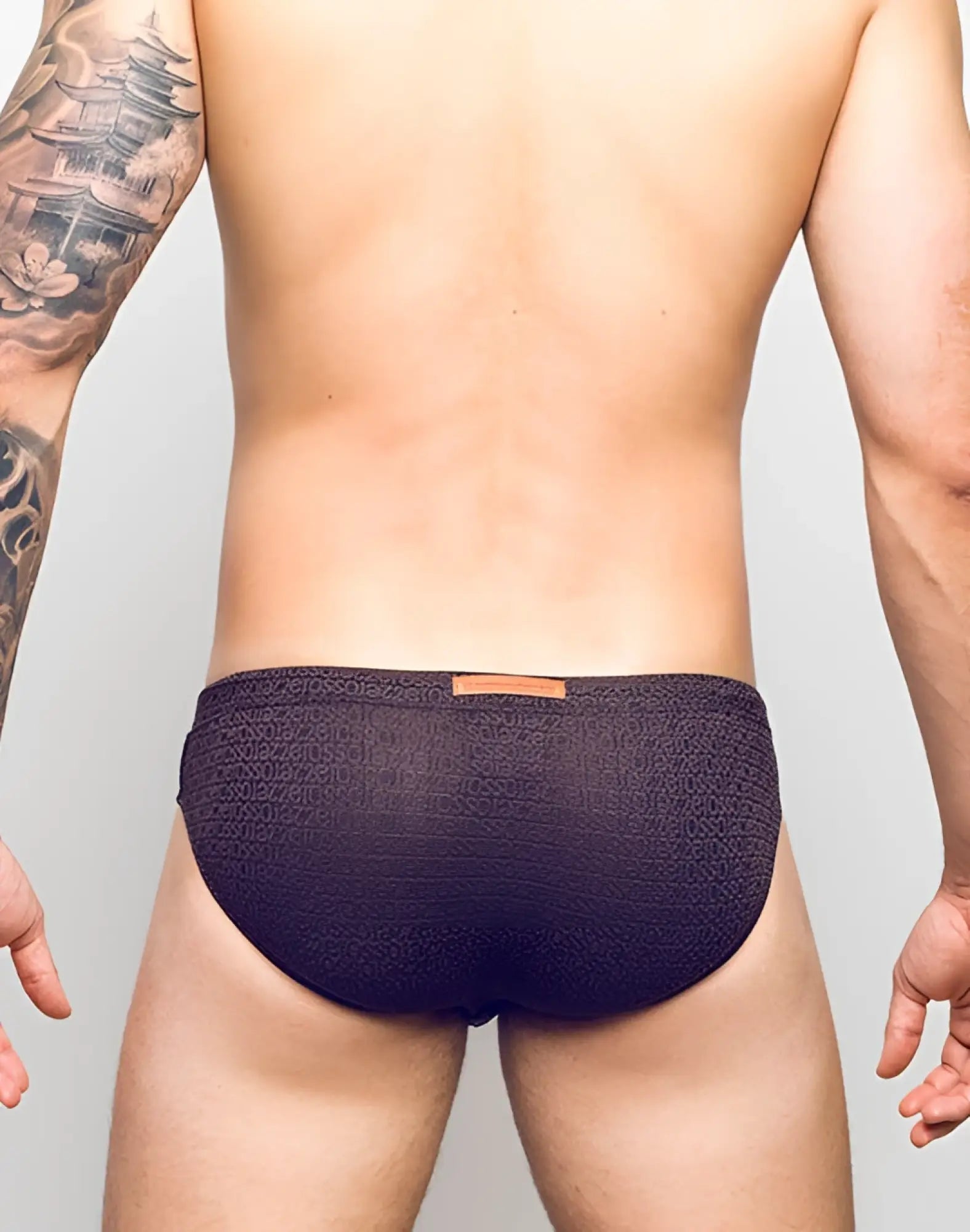 Dark purple 2eros v30 textured swim briefs with subtle pattern and orange leather-like waistband tag in signet black