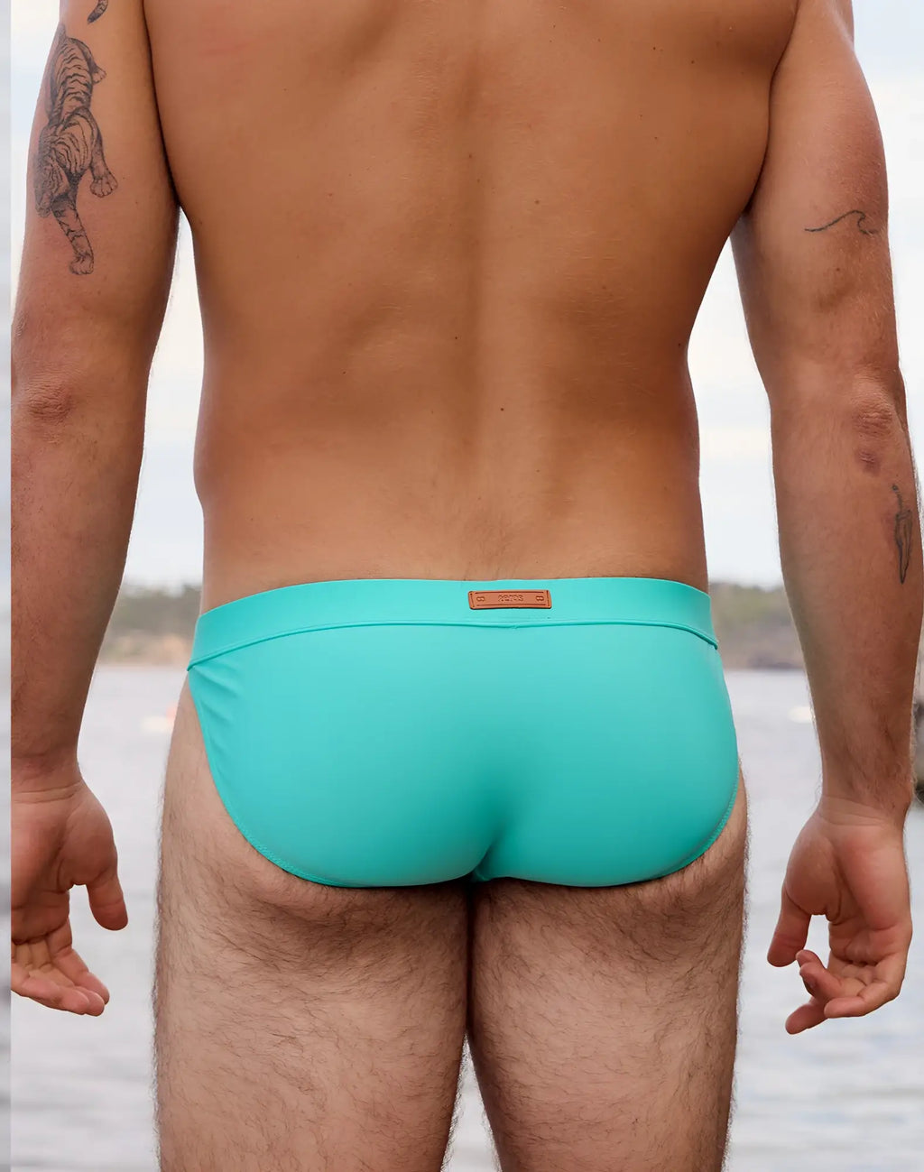 Turquoise 2EROS V50 Encore swim tanga with brown leather-like brand tag at waistband for neon blue swimwear collection