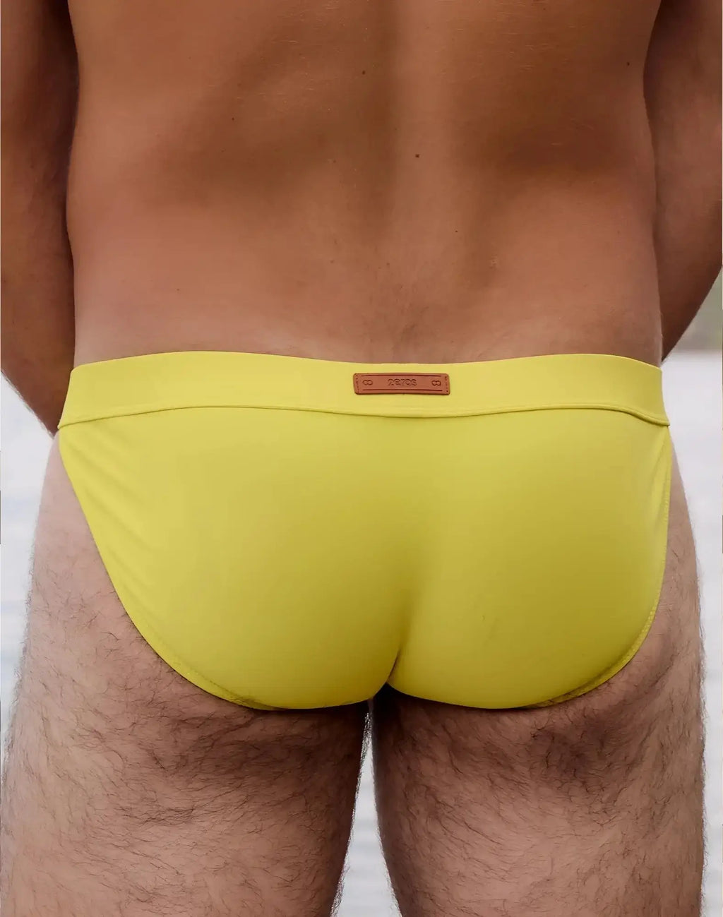 Bright yellow 2EROS V50 Encore swim tanga with brown leather-like brand tag at the waistband