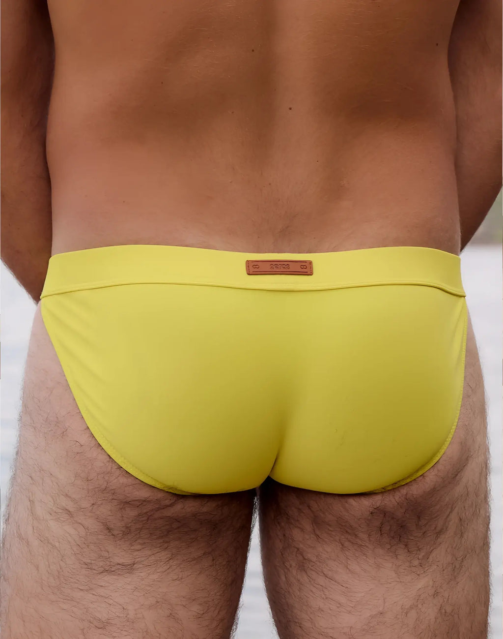 Bright yellow 2EROS V50 Encore swim tanga with brown leather-like brand tag at the waistband