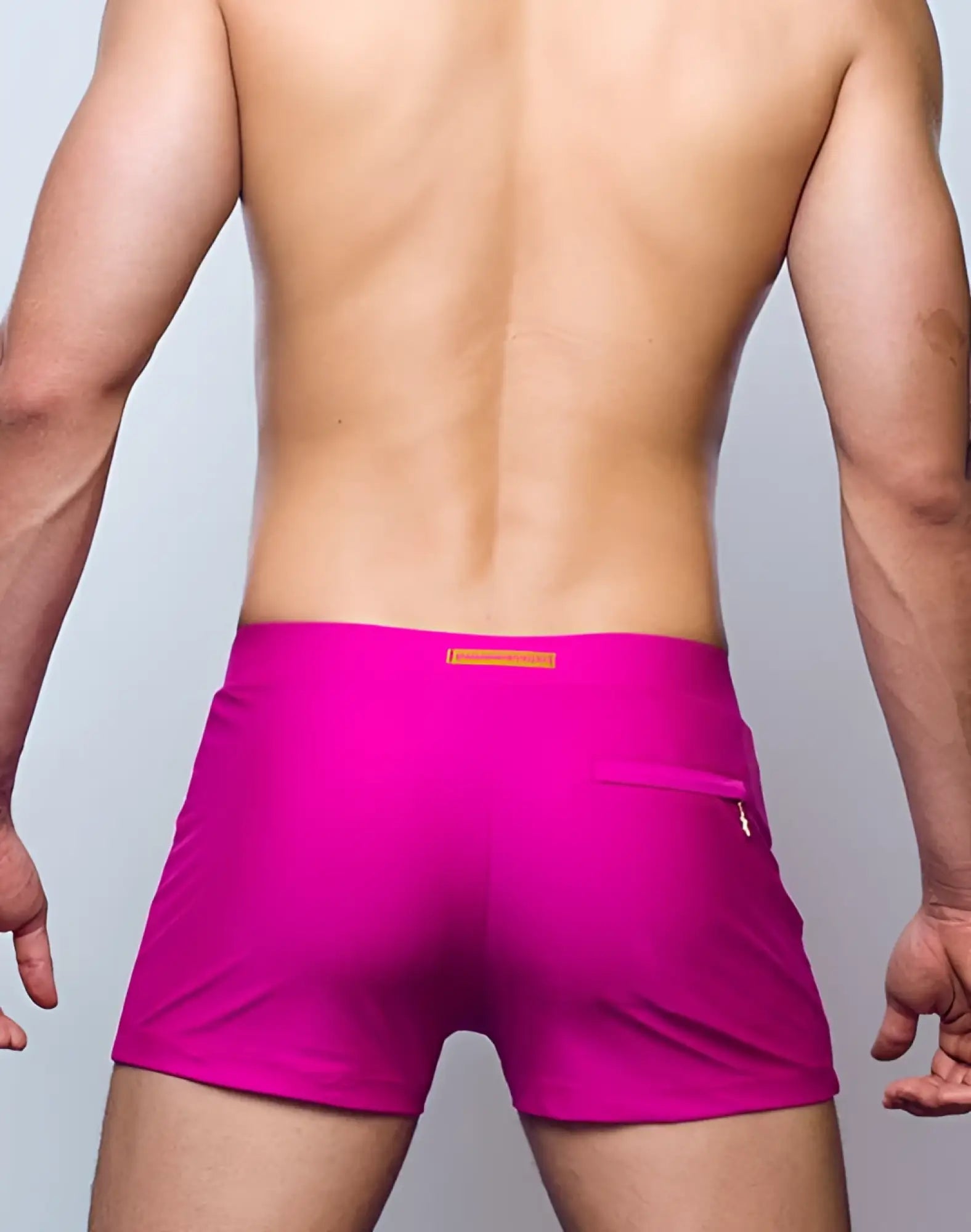 Vibrant fuchsia 2EROS V60 Bondi Series 2 swim trunks with subtle orange tag and zippered side pocket for secure storage