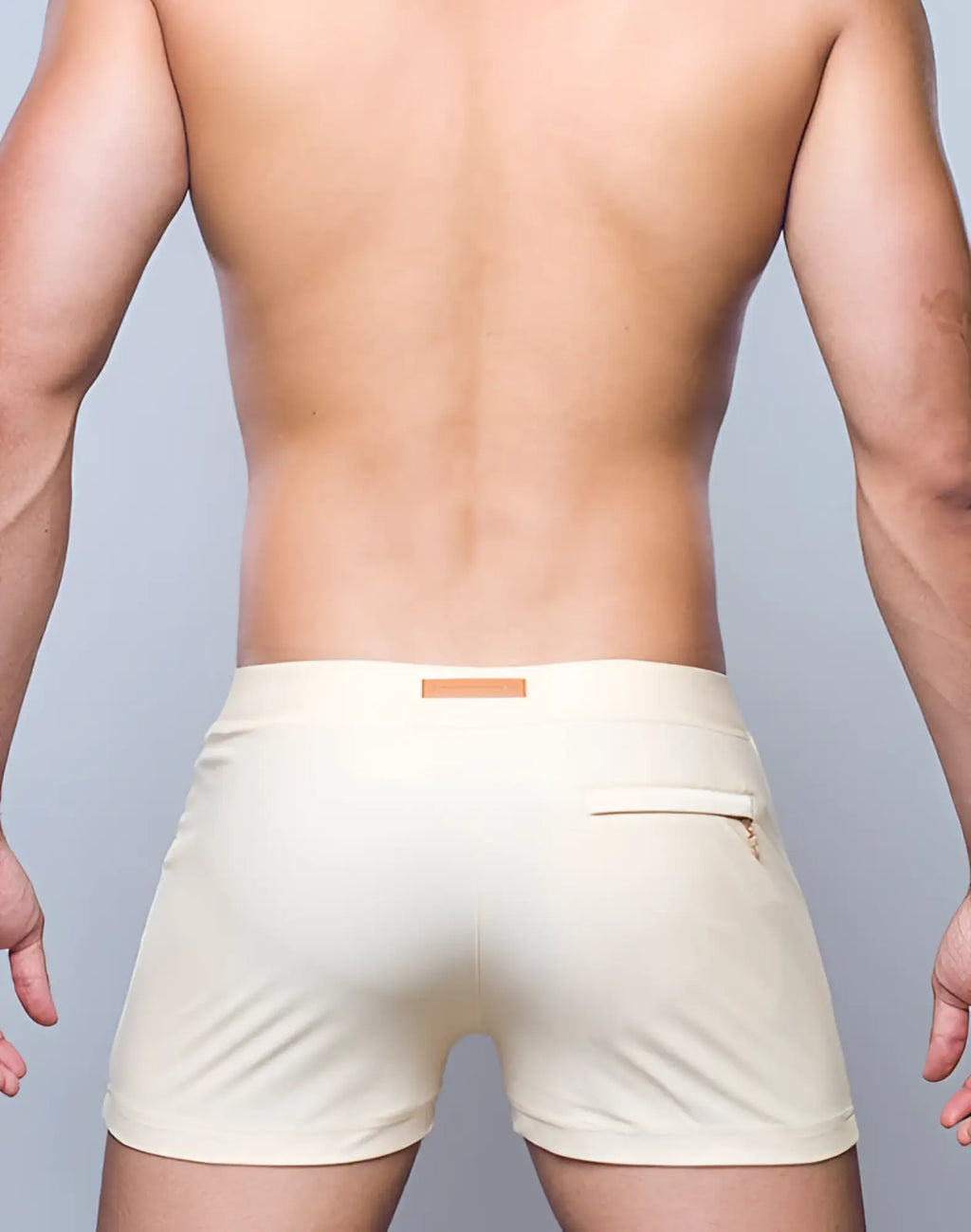 Cream-colored sleek 2EROS V60 Bondi Series 2 swim trunks with subtle texture and orange tag at the waistband