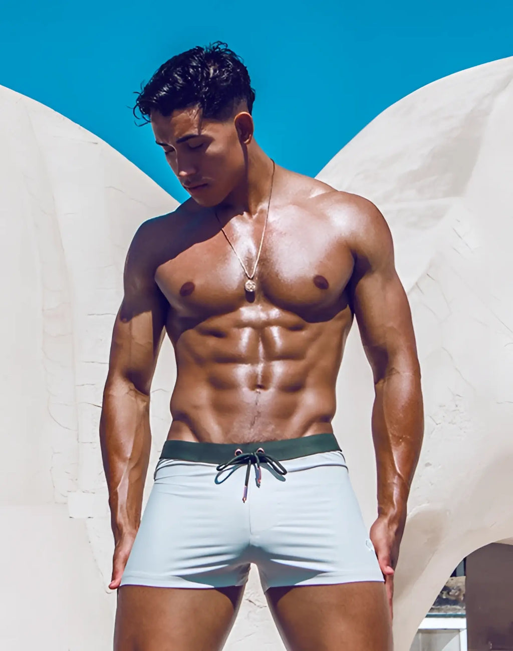 Light blue 2EROS V65 swim trunks with dark green drawstring waistband designed for comfortable beachwear