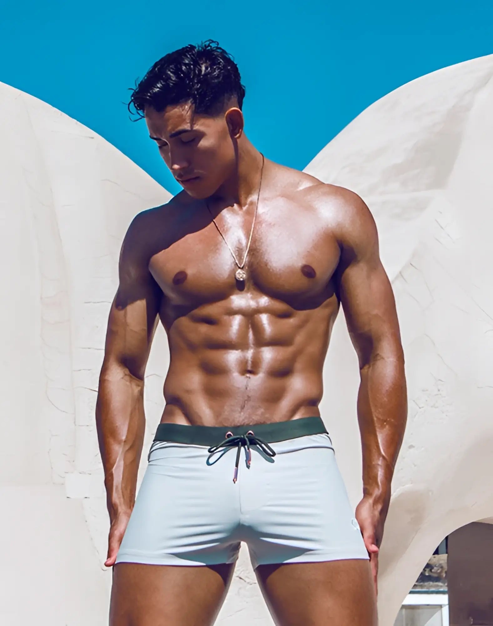 Light blue 2EROS V65 swim trunks with dark green drawstring waistband designed for comfortable beachwear
