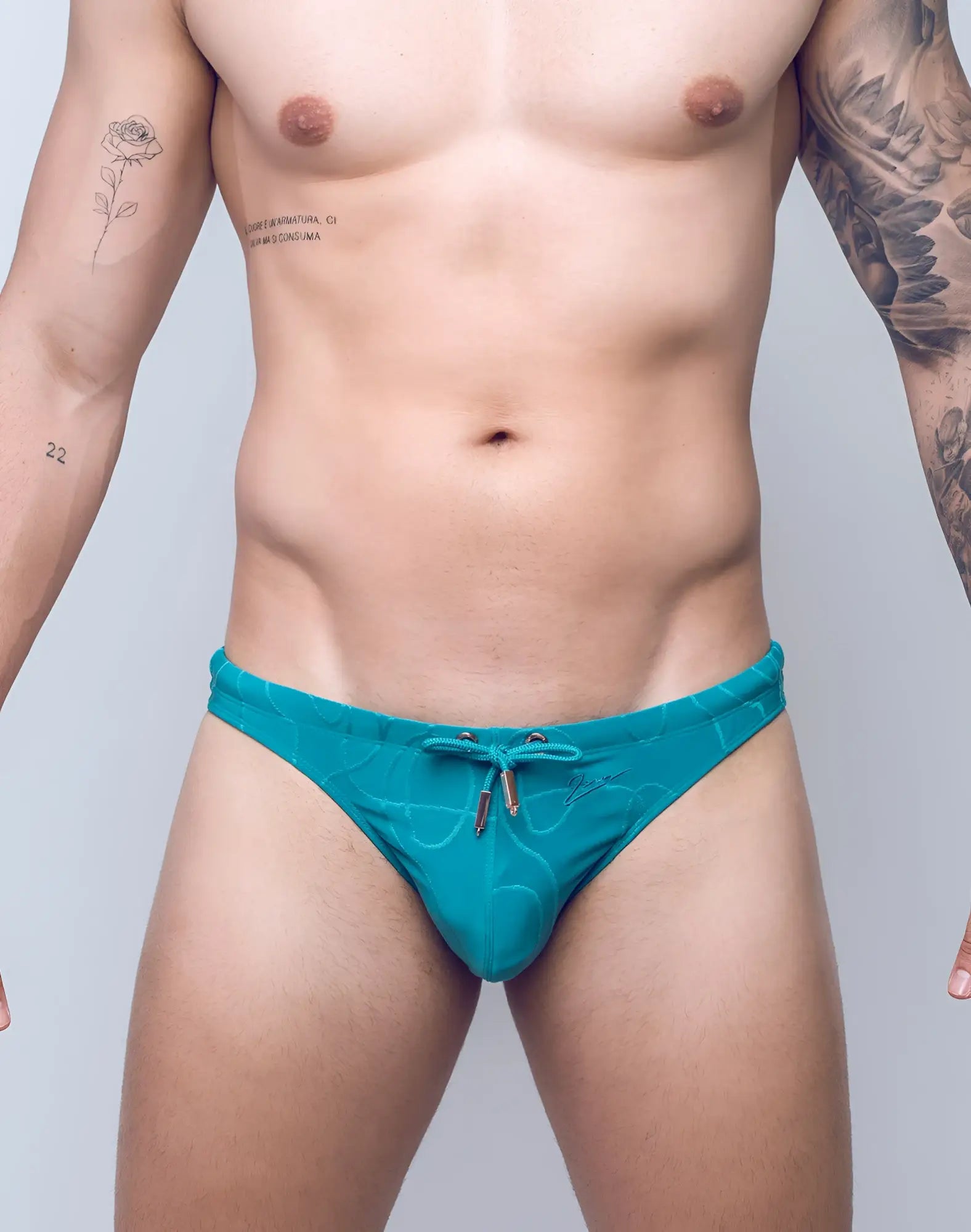 Turquoise 2EROS V80 textured swim thong with subtle wave pattern and metallic drawstring hardware