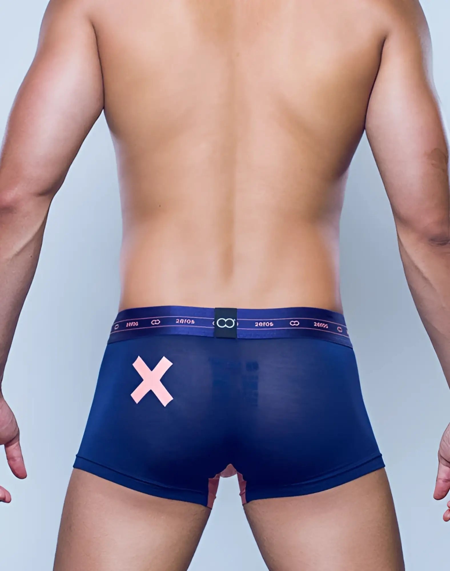Back side of navy blue sheer 2eros x-series trunk underwear with pink x and elastic waistband with 2019 text and infinity symbols