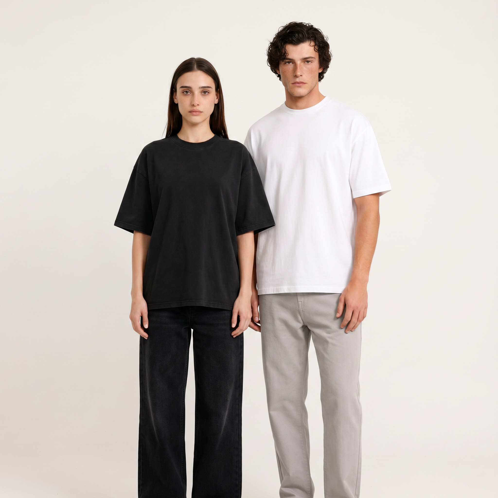 Woman in black and man in white Thread Lab Core Tees, oversized boxy fit, clean studio lifestyle photo.