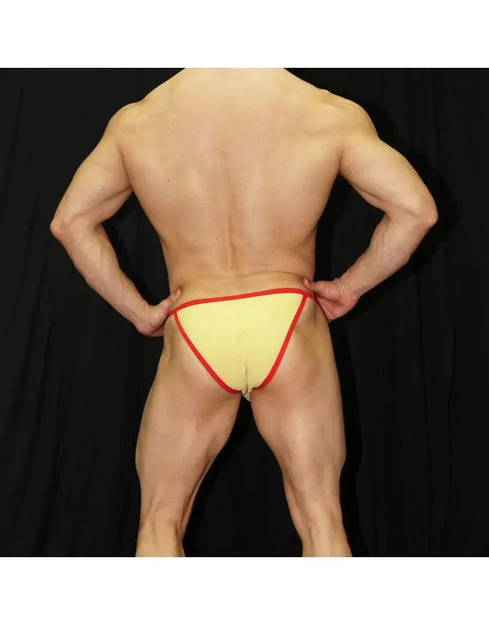 Light yellow men's bikini underwear with red trim shown on a model from the back by Arroyman.
