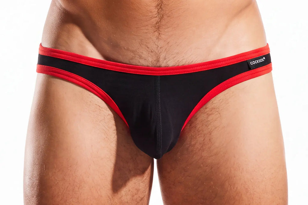 Close-up of a person's lower torso wearing black briefs with red trim on a white background.