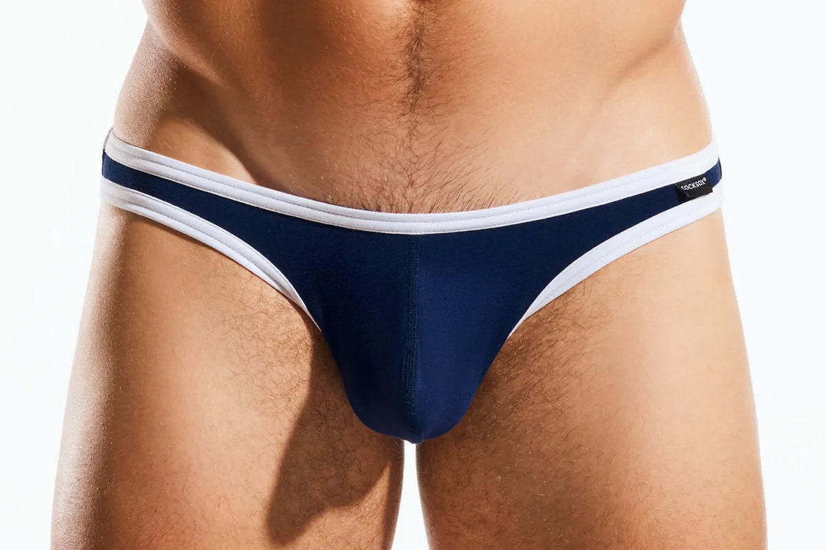 Close-up of a person's lower torso wearing navy briefs with white trim.