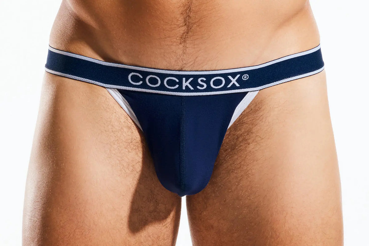 Close-up of a person's lower torso wearing navy blue underwear with a white waistband reading "COCKSOX".