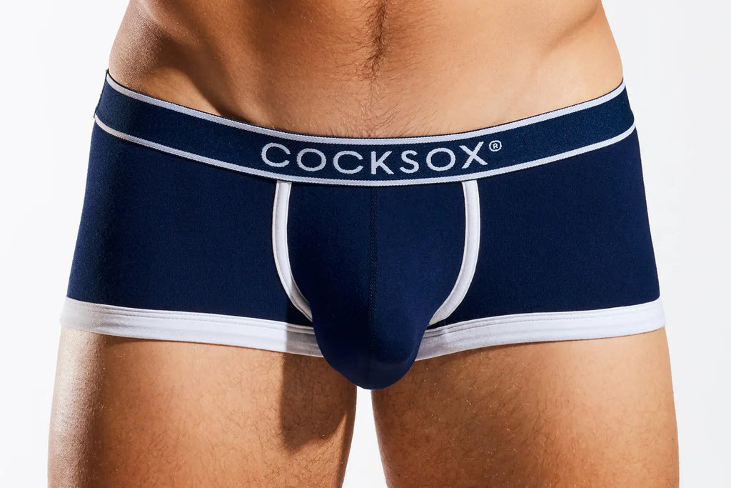 Close-up of a person's torso wearing navy blue underwear with a white waistband and white trim.