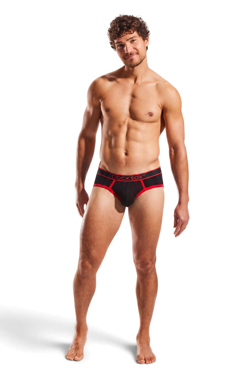 Standing man in black and red briefs on a white background.