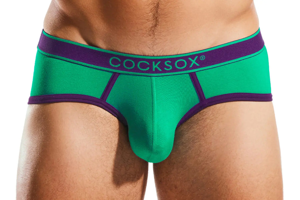 Close-up of a person's midsection wearing green briefs with a purple waistband.