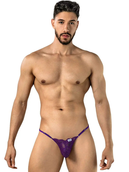 Man with dark hair and beard wearing purple sheer underwear, white background.