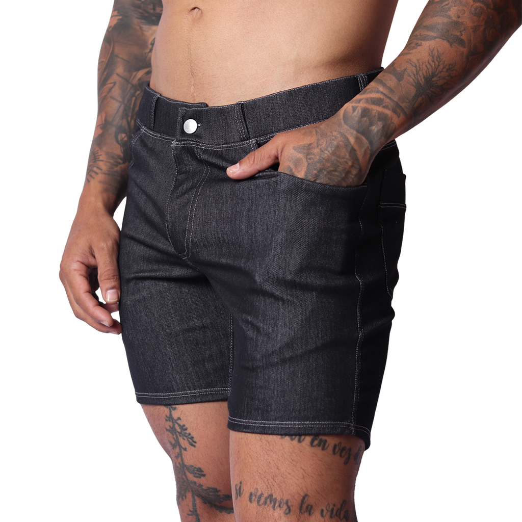 Side view of Gigo black denim shorts featuring contrast stitching, button fly, and slim-fit silhouette on tattooed model.