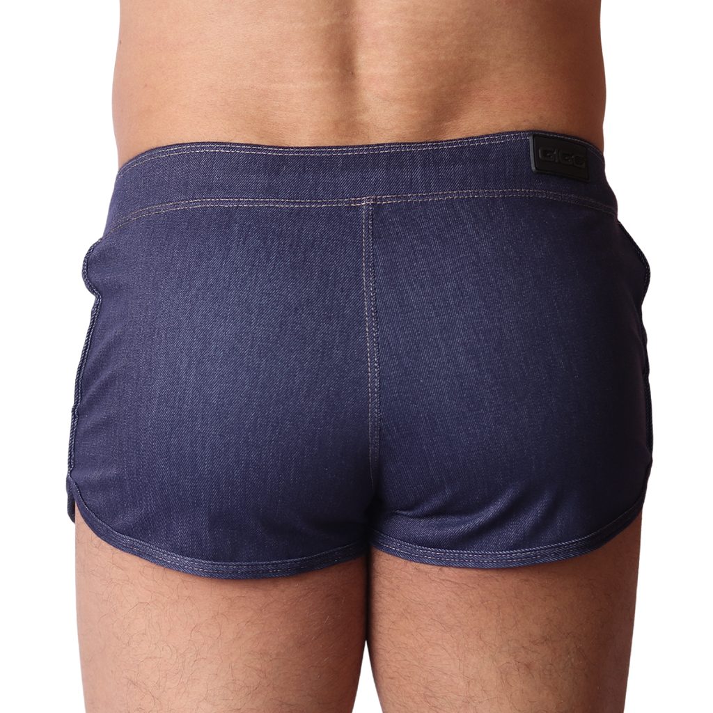 Back view of Gigo blue denim hot shorts with contrast stitching and branded waistband patch on a black background.