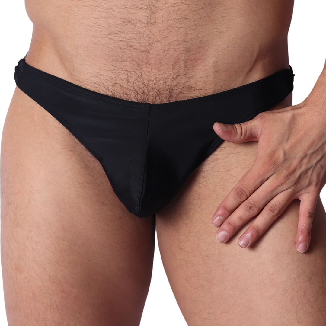 Front view of Gigo Dinamic black swim g-string in smooth, stretchy fabric with hand resting on hip.