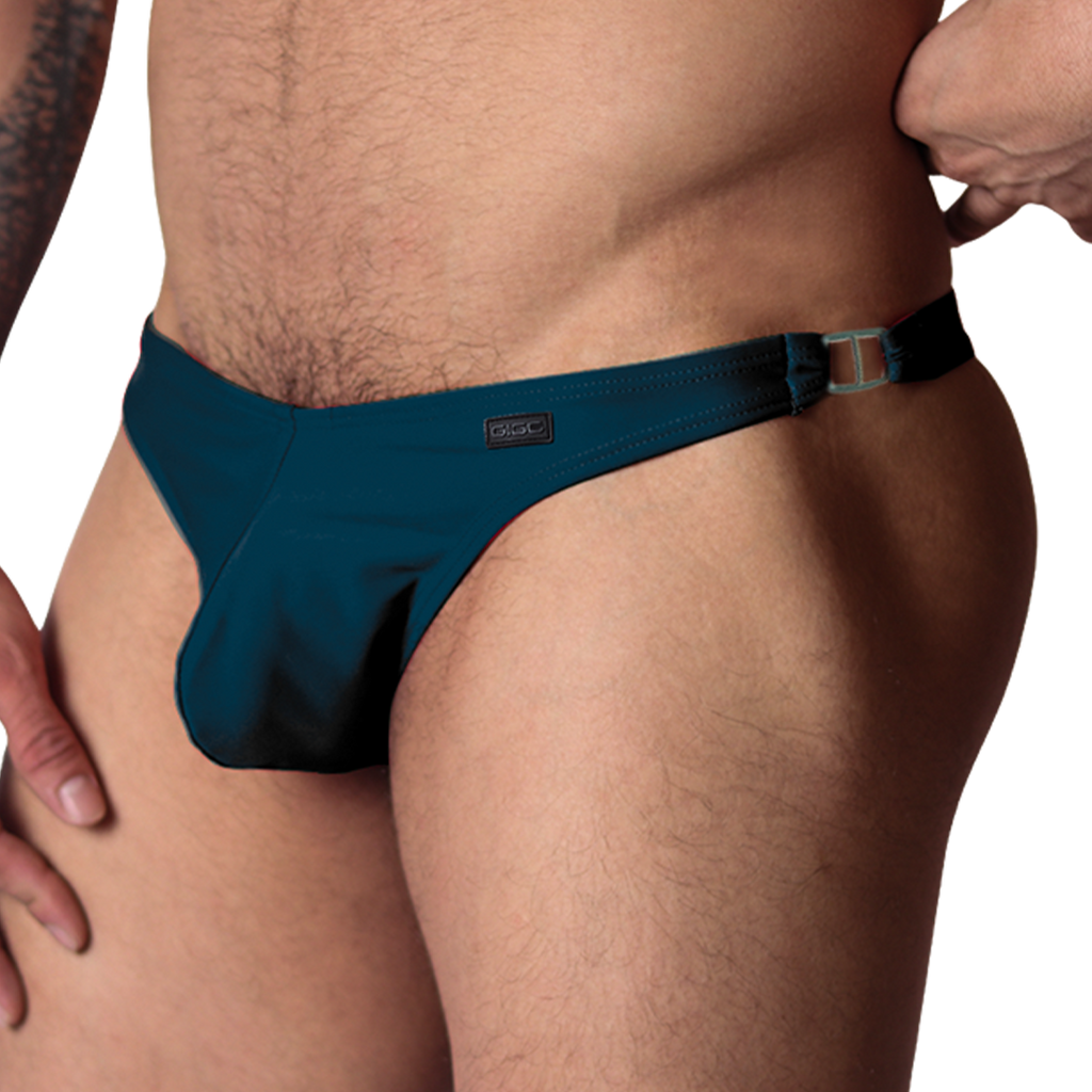 Gigo Dinamic green swim G-string, side view showing stretch fabric, metal side ring, and Gigo branding patch.