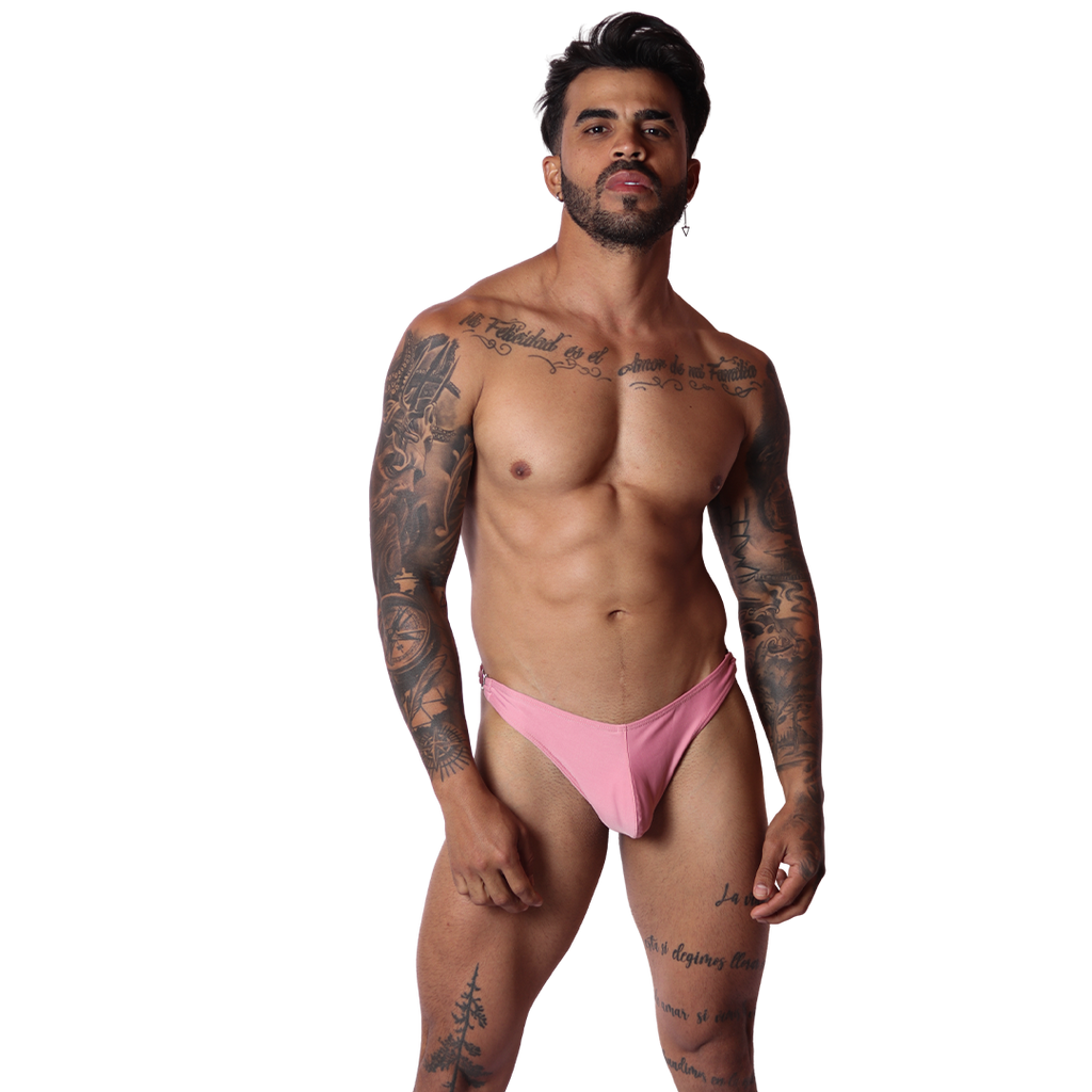 Front view of Gigo Dinamic pink swim g-string in smooth stretch fabric worn by a tattooed model on black background.