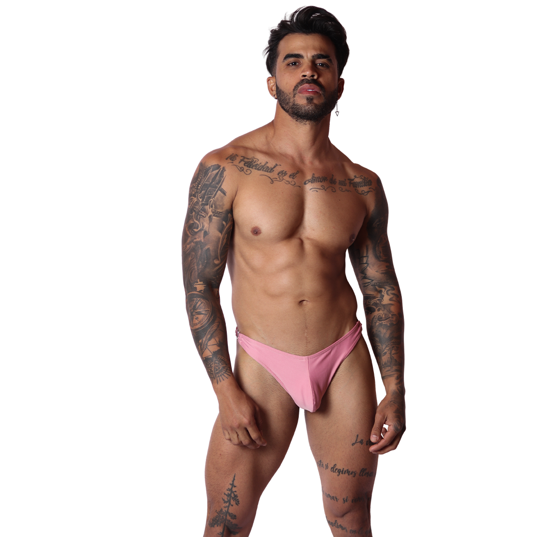 Front view of Gigo Dinamic pink swim g-string in smooth stretch fabric worn by a tattooed model on black background.