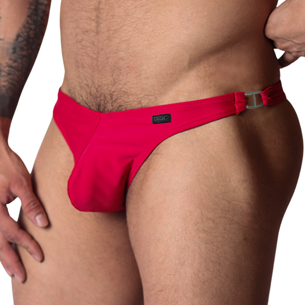 Front view of Gigo Dinamic red swim G-string with metallic side ring detail and logo tag on smooth fabric.