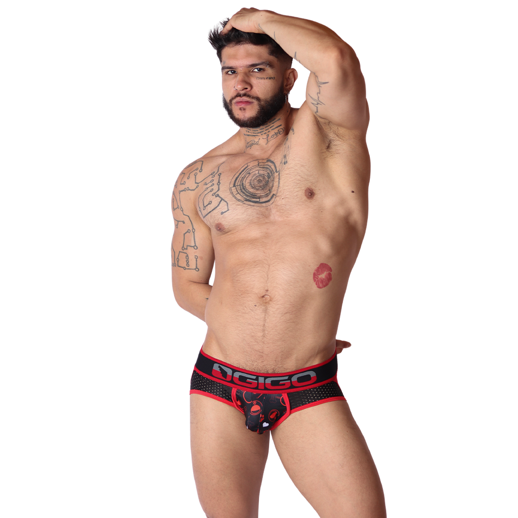 Front view of Gigo red mesh jockstrap with dog print pouch and branded elastic waistband on a tattooed model.