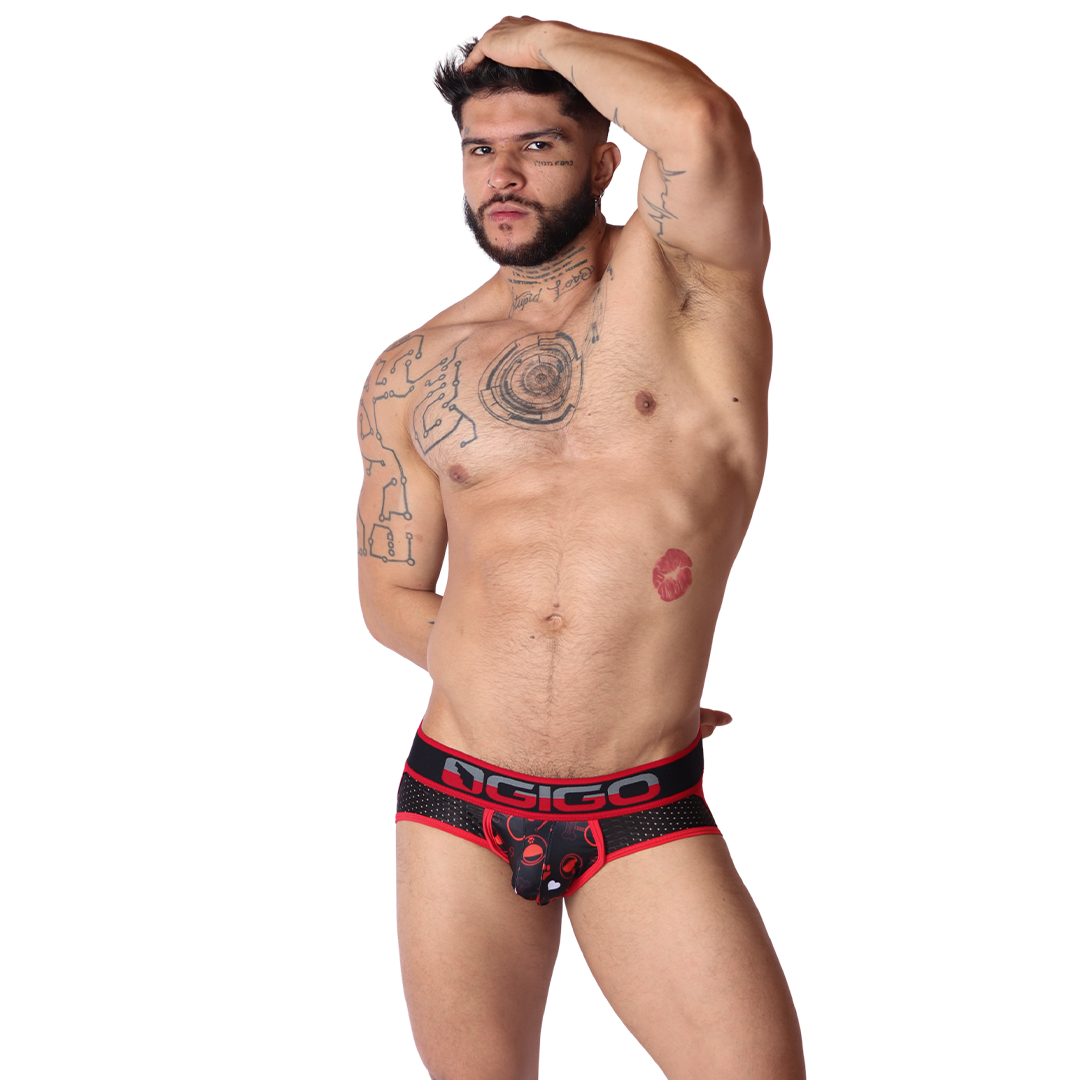 Front view of Gigo red mesh jockstrap with dog print pouch and branded elastic waistband on a tattooed model.