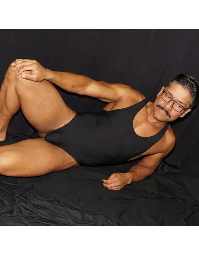 Black microfiber bodysuit thong worn by a model featuring a racerback design by Arroyman.