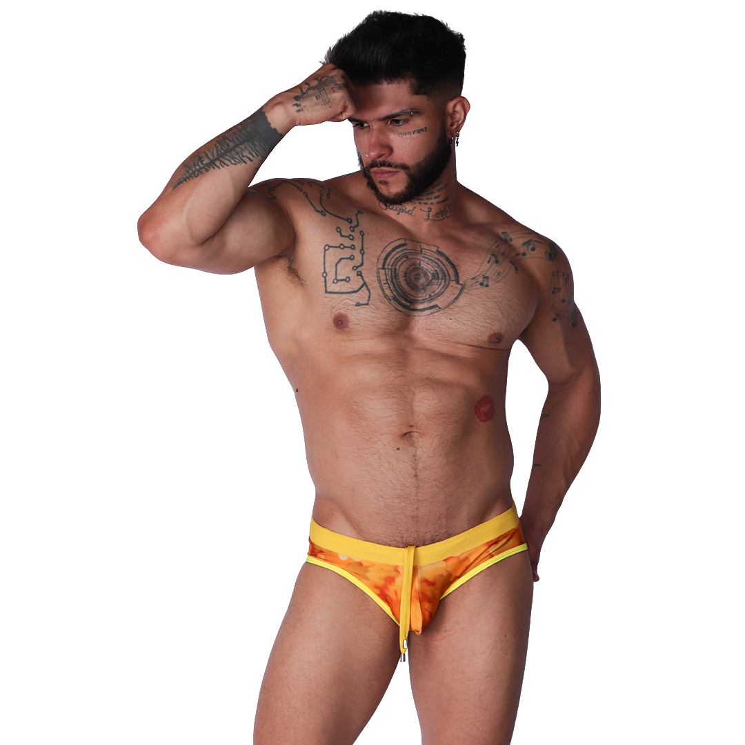 Front view of Gigo yellow floral print swim brief with adjustable drawstring and stretchy fabric on a tattooed male model.
