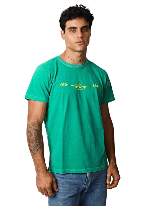 Man wearing a green T-shirt with a small yellow aeroplane graphic.